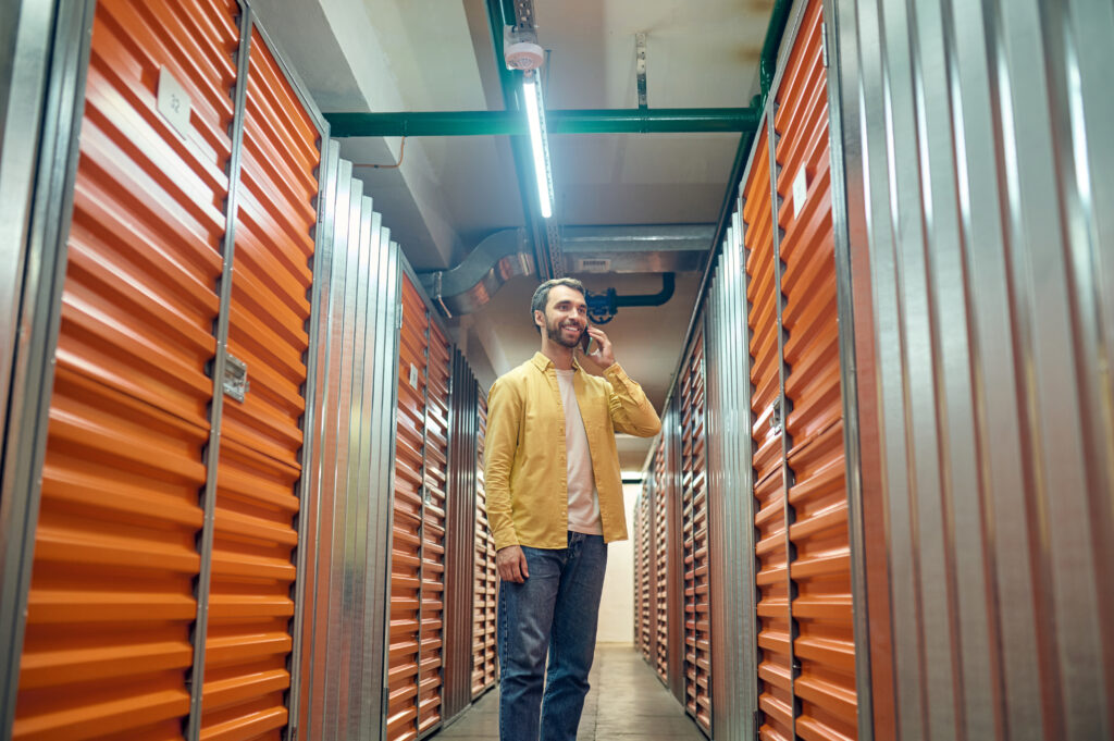 Man following up with storage tenant over the phone inside a storage facility